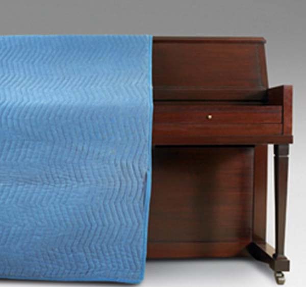 Piano covered in padding blanket
